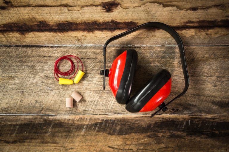 Earplugs and Ear Protection laid out on a wooden style background