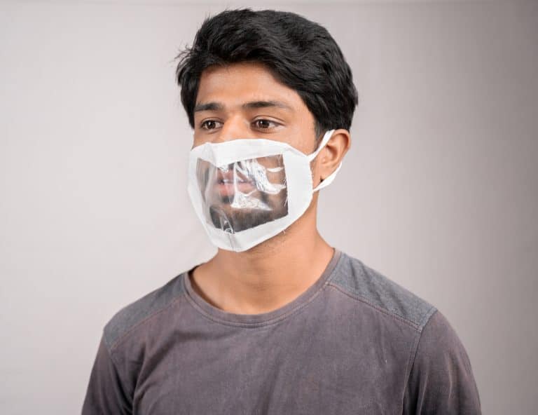 young man with transparent Medical face mask, to help hearing impermeant or deaf people to understand lipreading during coronavirus or covid-19 outbreak.