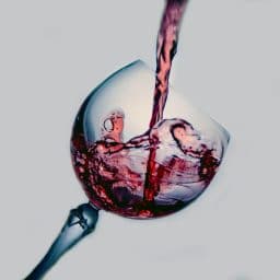 Red wine being poured into a glass.
