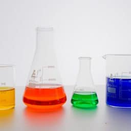 Colorful liquid chemicals in beakers.