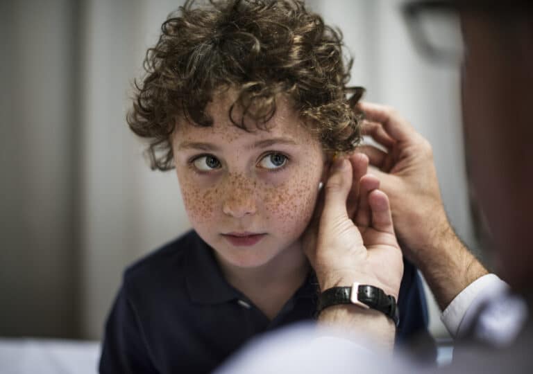 Doctor performs ear exam on young boy