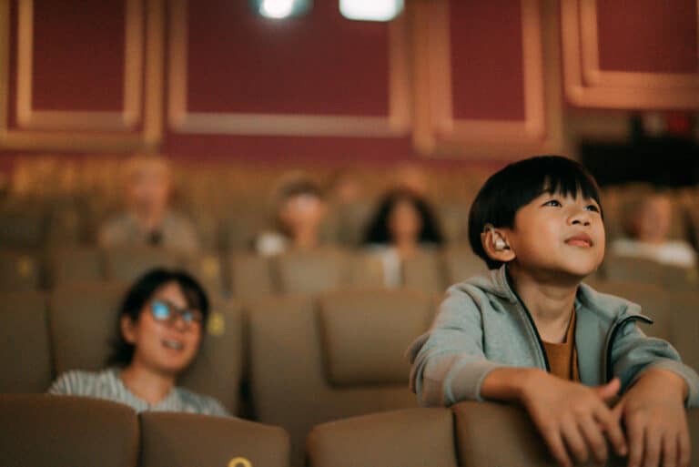 Boy with hearing aid sees a movie