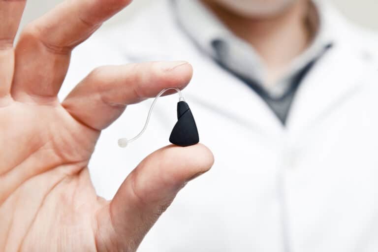 Doctor holding modern hearing aid