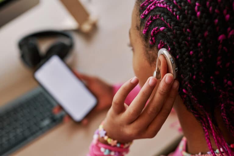 Person with hearing aids using their hearing aids app to adjust the volume